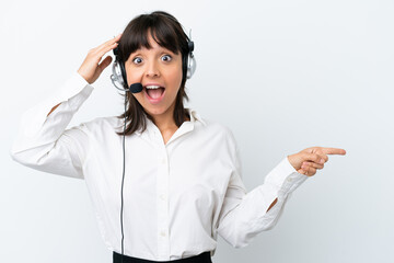 Telemarketer mixed race woman working with a headset isolated on white background surprised and pointing finger to the side