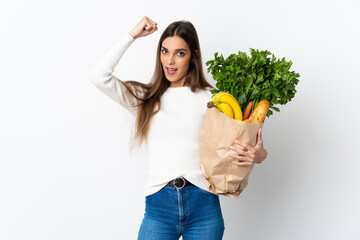 Young caucasian woman buying some food isolated on white background celebrating a victory