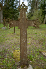 Old rusty metal cross in cemetery
