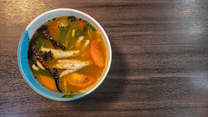 Chicken Feet Spicy Soup,Thai local food,hot and very spicy soup made from chicken feet, 'Tom Yum Chicken Feet Soup', a spicy and aromatic Thai delicacy served in a traditional bowl,