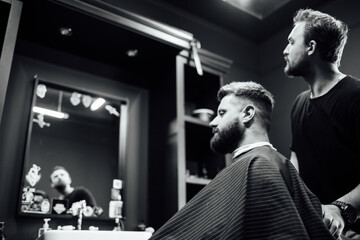 A man is getting his hair cut by another man in a barbershop