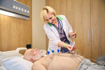 Lady doctor with white hair shows cardiogram results