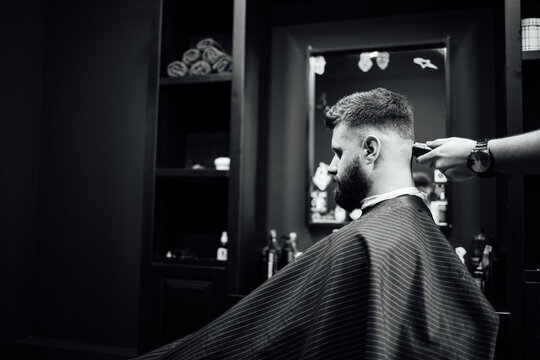 A man is getting his hair cut by a barber
