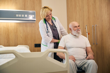 Old patient sitting and smiling on a wheelchair