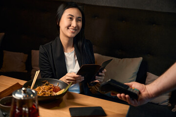 Smiling woman holding check with information about meals prices