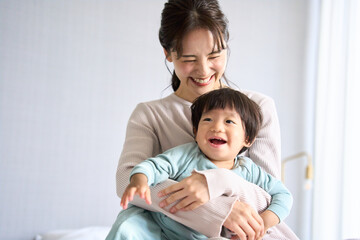 ベッドで触れ合う母と1歳10ヶ月の息子