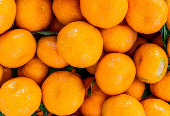 orange mandarin background of fresh juicy tangerines close up, vegan friut conception of citrus