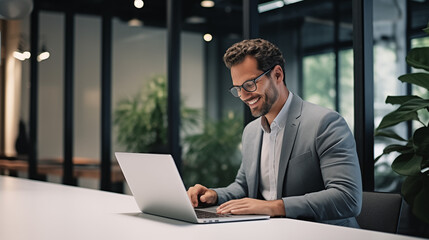 Smiling Businessman Working on Laptop in Modern Office