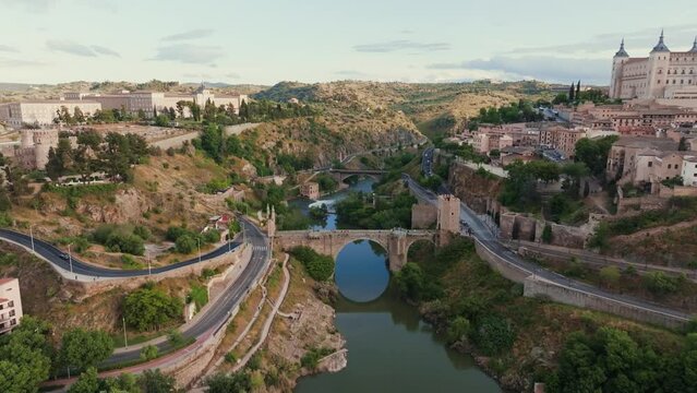 Plano a&eacute;reo con dron sobre la ciudad hist&oacute;rica medieval de Toledo, Castilla La Mancha, Espa&ntilde;a. R&iacute;o tajo junto al Puente de Alc&aacute;ntara y el Alc&aacute;zar.
