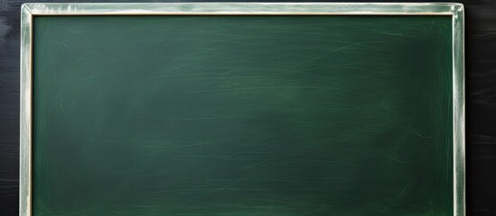 A hand holding chalk on a green chalkboard with plenty of copy space for writing and drawing