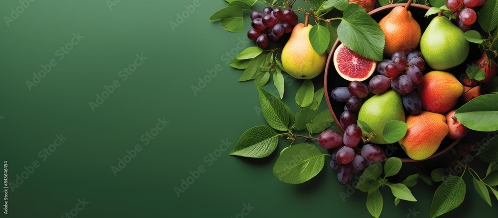 Poster copy space image of grape peach and pear fruits arranged on a green background with leaves viewed fr
