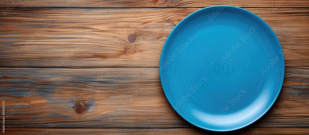 Poster Top view of empty blue plate on wooden background Empty space for your design. copy space available