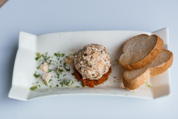 Cheese balls with herbs on a black board on a white background