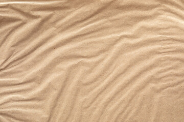 A close-up image of brown paper with a wrinkled texture. The paper is light brown in color and has a natural, organic feel.