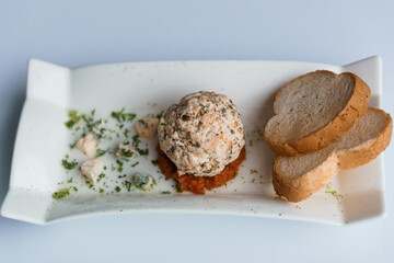 Cheese balls with herbs on a black board on a white background