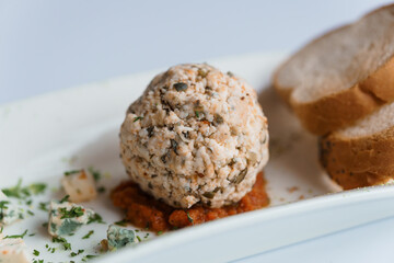 Cheese balls with herbs on a black board on a white background