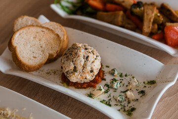 Cheese balls with herbs on a black board on a white background
