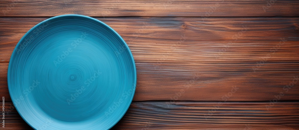 Poster Top view of empty blue plate on wooden background Empty space for your design. copy space available