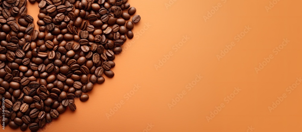 Poster top view of a light orange background featuring a heart shaped pile of coffee beans providing ample 