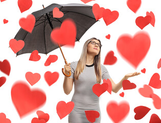 Young woman with an umbrella under red hearts
