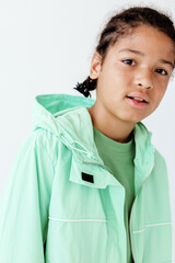 Stylish young boy in green jacket and logo tshirt exuding trendy urban fashion vibes