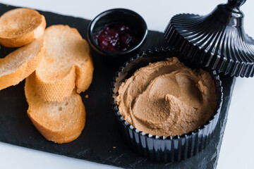 Pate with sauce and croutons on a black board