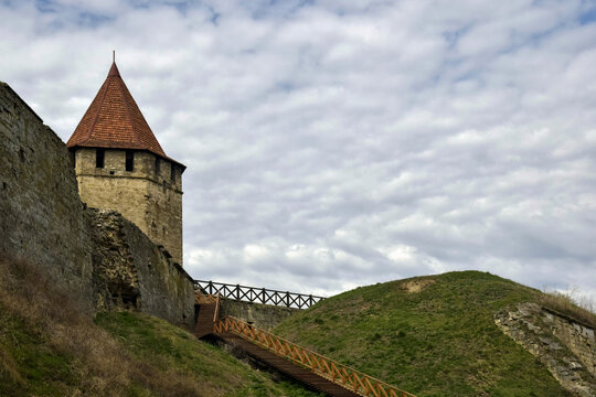 Old Stone Fortress With Conical Tower Under Cloudy Sky in Springtime. Copy space. Selective focus.