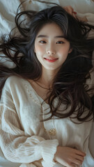 Fototapeta premium Korean model woman in comfortable clothes lying on bed, warm model house