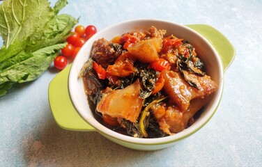 Assamese recipe Pork with mustard green. Pork meat cooked with mustard green locally known as Lai xaag. The greens absorb the fat and make the meat taste milder.