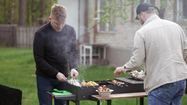 Two guys cooking meat