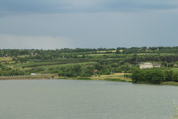 A lake with trees and houses in the background