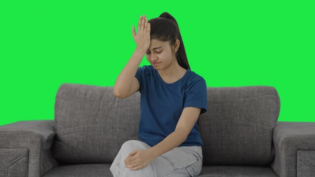 Frustrated Indian teenage girl slapping her head Green screen