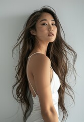 Fototapeta premium beautiful asian girl, fit, tan, stylish, realistic, dark brown eye, long wavy hair, hyperdetail photography, soft light, in her fitted white dress, happ, lean on, side profile, white background cool 