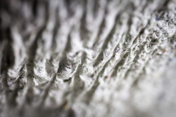 Extreme close up of old gray handmade paper mache with a structure and rough texture.