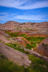 Badlands National Park in Southwestern South Dakota, USA: The beautiful geological formation with eroded channels, canyons, rugged peaks, and green wild plants