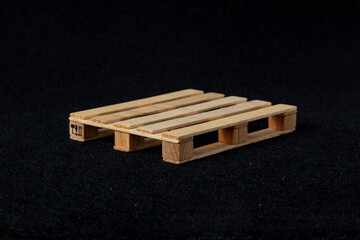 Reduced model wooden euro pallet on black felt background....
