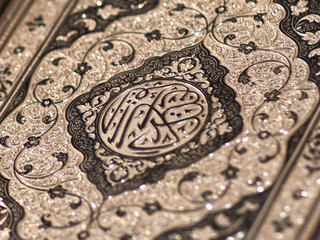 Islamic Book Quran with golden arabic calligraphy that means Al-Quran