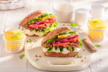 Fresh sandwich with pulled beef, gherkins and tomato.