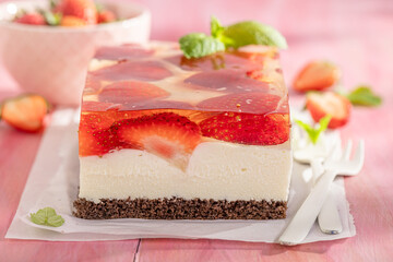 Homemade strawberry cheesecake with transparent jelly and cream.