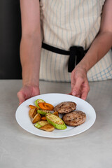 Ready-to-eat meatballs, cutlets or meat patties served on a plate with grilled vegetables. Home cooking, traditional recipes, and delicious meal presentation.