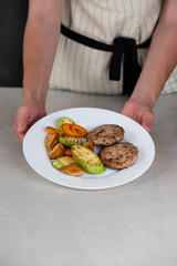 Ready-to-eat meatballs, cutlets or meat patties served on a plate with grilled vegetables. Home cooking, traditional recipes, and delicious meal presentation.