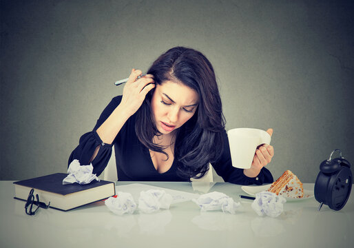 Desperation and super busy young woman working in the office on a messy desk