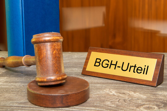 Symbolbild BGH (Bundesgerichtshof): Richterhammer neben einem Messingsschild mit der Aufschrift BGH-URTEIL (Composing)
