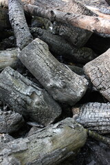 Fototapeta premium A pile of charcoal and firewood on a campfire.