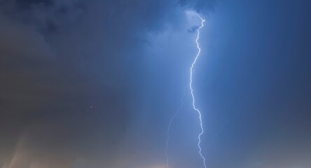 Lightning in the blue sky with clouds at night in the city. Santos city, Brazil.