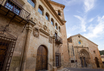 Palace of Nuñez Cortes in Chinchila de Montearagon in Albacete, Castilla la Mancha, Spain, Plateresque style in the foreground, with the parish church of Santa Maria del Salvador in the background