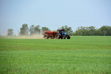 a blue tractor is plowing a field copy space    