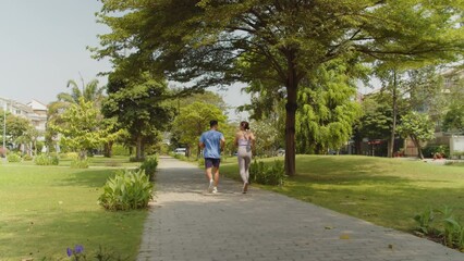 Static shot of diverse sportspeople running in city park while training for upcoming marathon