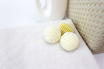 Three laundry balls balls on towels close up. Eco-friendly household concept. Selective focus, copy space