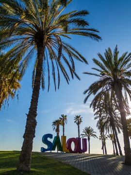 colorful letters of Salou town, palm trees andl beach at sunset, Catalonia, Spain